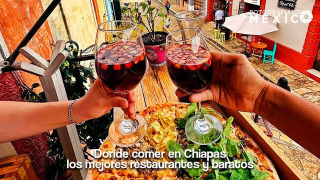 Brindis con copas de vino tinto sobre una pizza artesanal en la terraza de un restaurante en San Cristóbal de las Casas