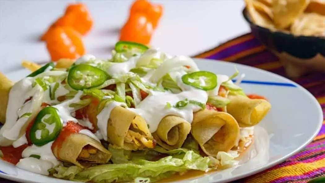 Plato con cinco flautas mexicanas doradas y crujientes servidas en restaurante