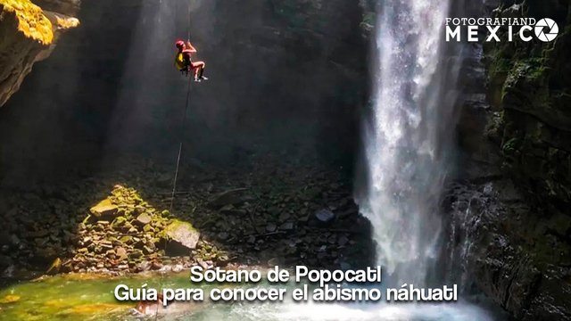 Explorador descendiendo en rappel por una cuerda dentro del Sótano de Popocatl junto a una gran cascada subterránea
