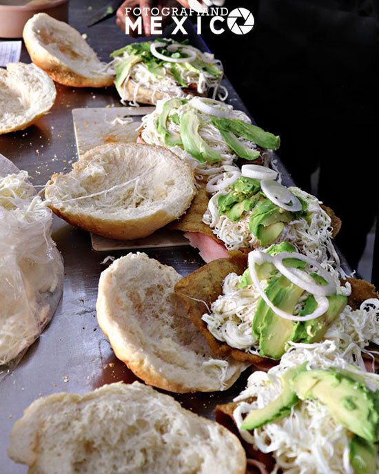 Cemita poblana rellena de carne, queso, aguacate, cebolla, pápalo y salsa