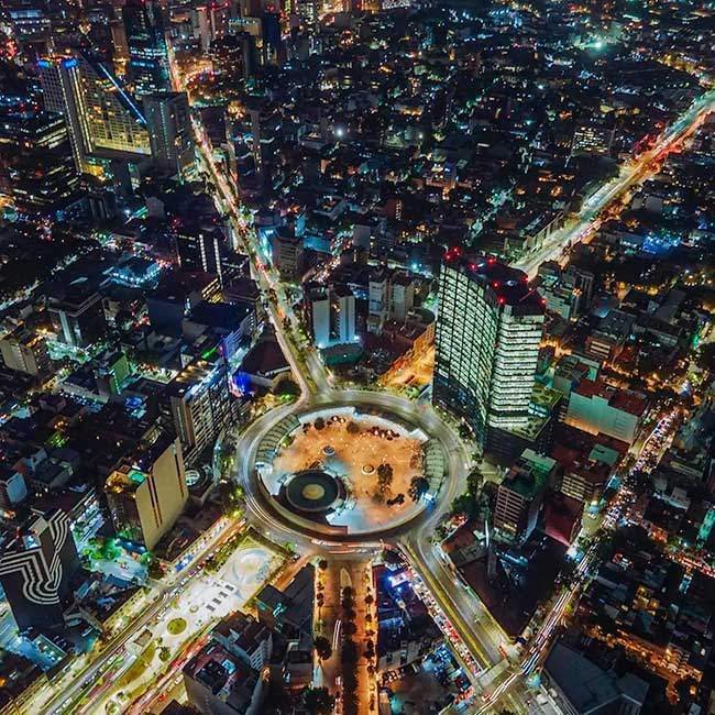 Vista panoramica aérea y nocturna de la Glorieta de los Insurgentes iluminada con luces de trafico en la Ciudad de Mexico.