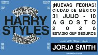 El cantante británico Harry Styles sonriendo con un micrófono en la mano sobre el escenario de un estadio iluminado